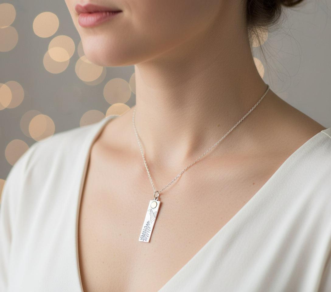 Necklace with a pendant featuring a tree design on a white mannequin bust.